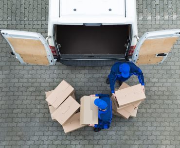 Man unloading truck of packages after visiting multiple warehouses