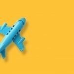 blue plastic toy plane on yellow background with space